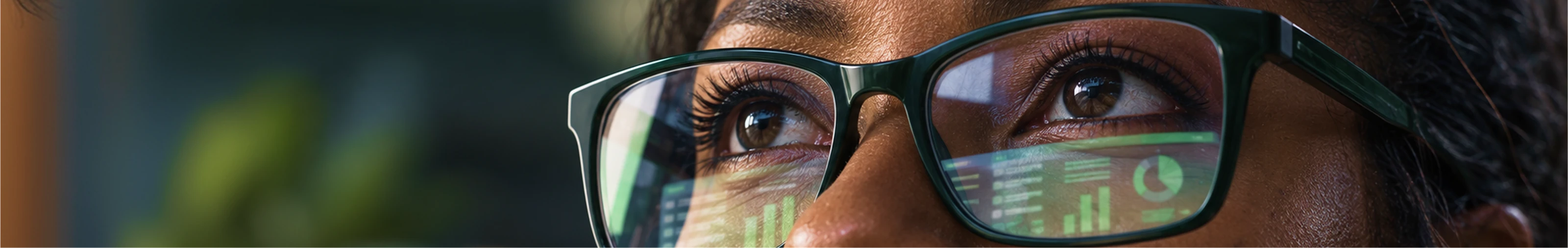 Close dos olhos de uma profissional com óculos refletindo informações da plataforma