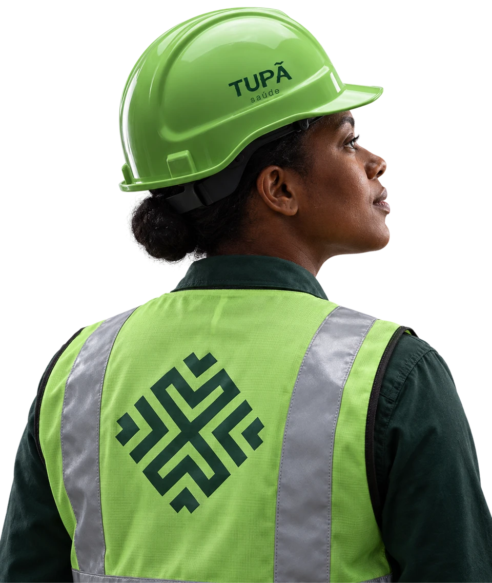 Profissional da Tupã de perfil, com capacete verde e colete de segurança